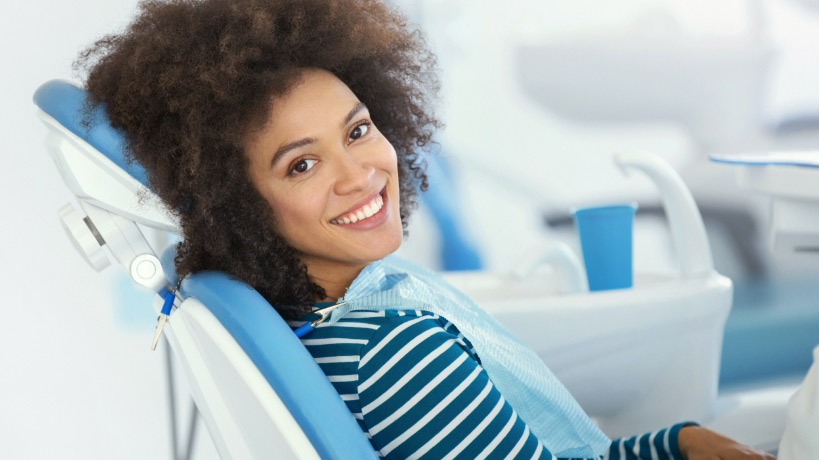 Woman Sitting In Dental Chair And Smiling